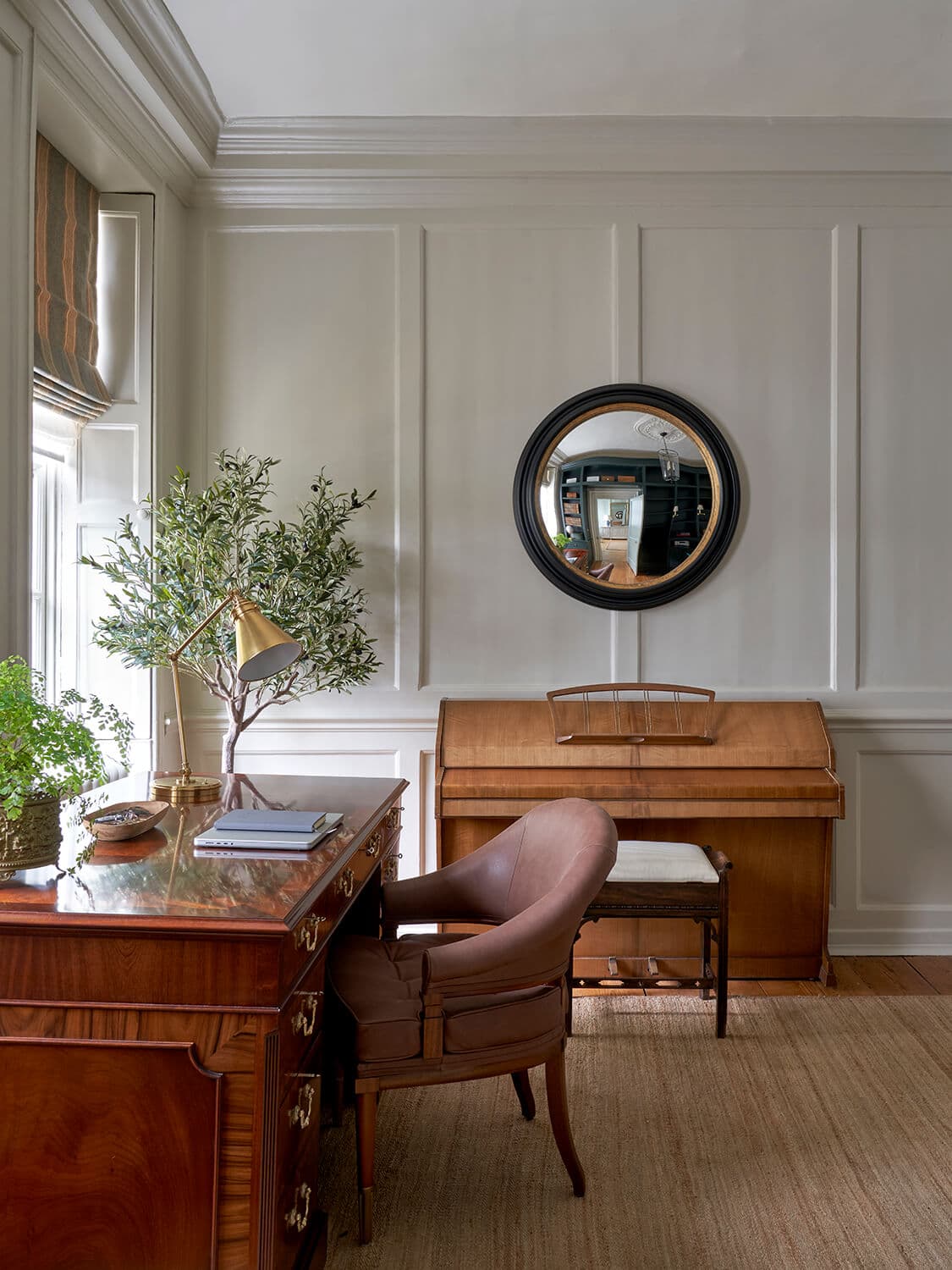 Close view across the study desk, showing books, a globe and aged brass detailing