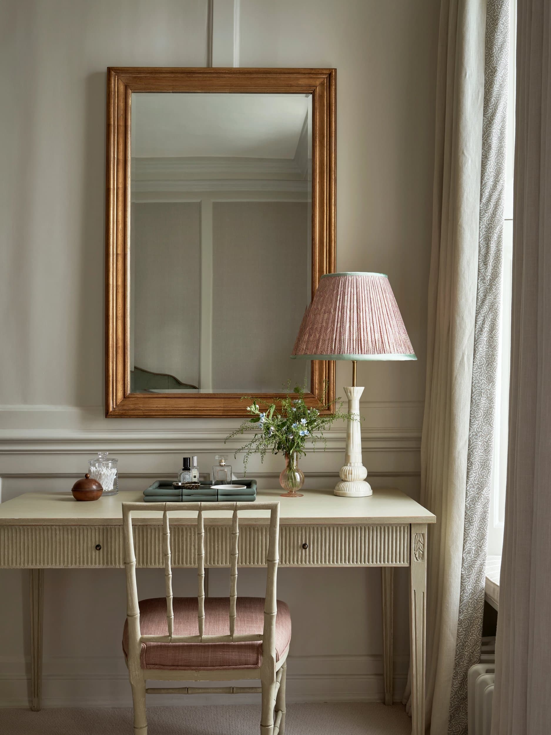 Further view of the principal bedroom, with full-length curtains and soft daylight across the bed